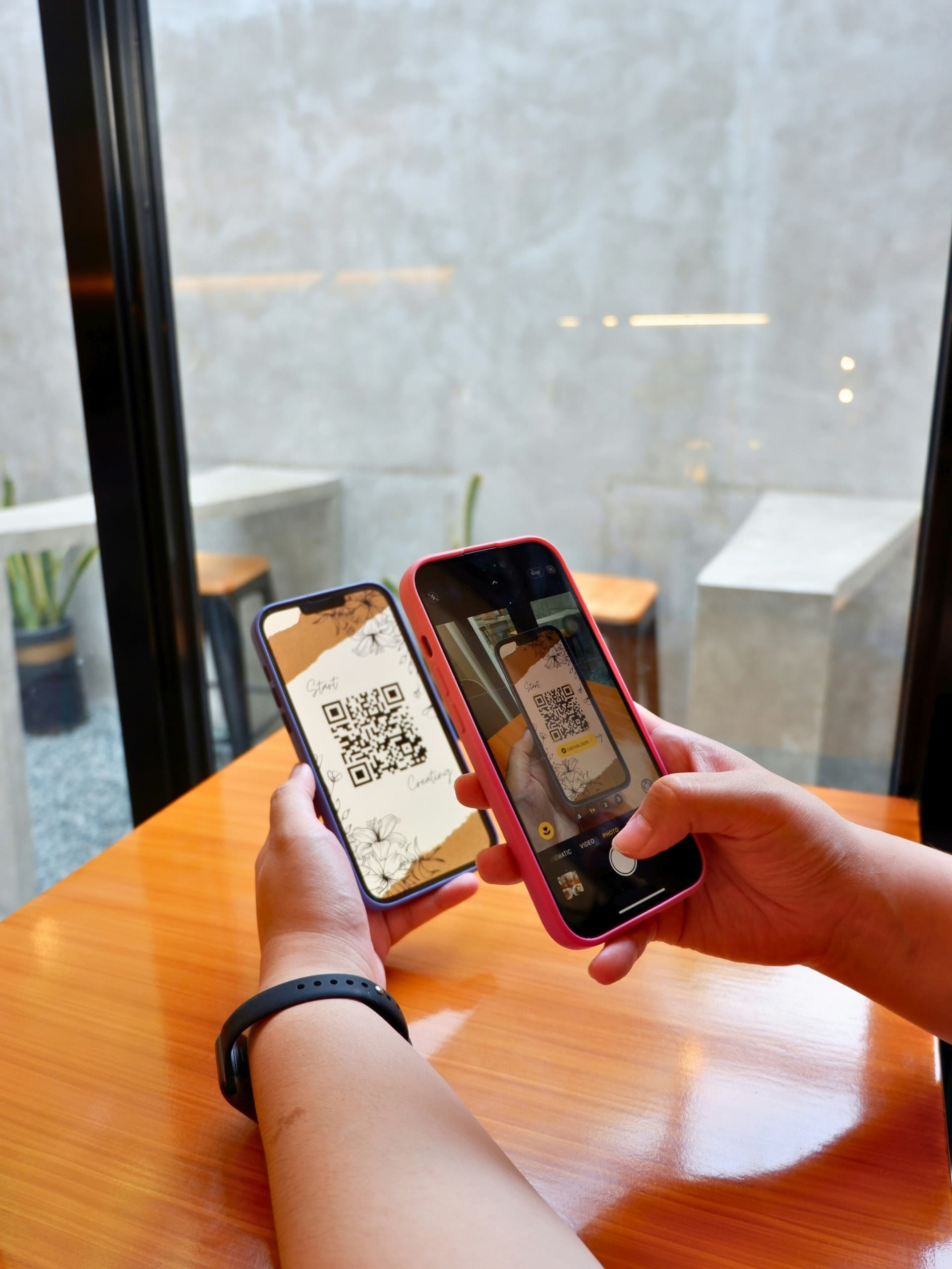 Two phones, one showing a QR code and the other scanning it with the camera